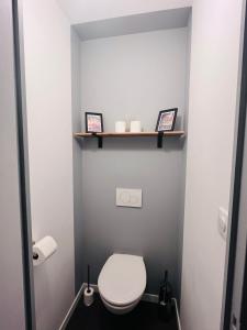 a small bathroom with a toilet and two framed pictures at Le Bastide Cosy in Carcassonne