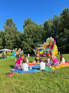 a group of children sitting on a blanket in a park at Scandi Resort in Zator