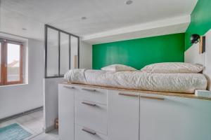 ein Schlafzimmer mit einem Bett auf den Schränken in der Unterkunft Le Rubis de Gonesse •CDG•Parc Expo•Astérix in Gonesse
