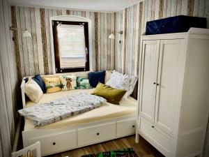 Cette chambre comprend un canapé avec des oreillers et une fenêtre. dans l'établissement Ferienwohnung-Familienidylle-im-Vogtland-80qm, à Neumark