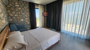 a bedroom with a large bed and a large window at RUSTICO in Shirokë