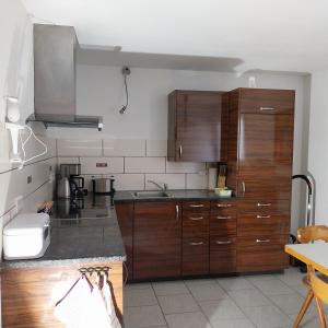 a kitchen with wooden cabinets and stainless steel appliances at Souterrainwohnung in Gottmadingen