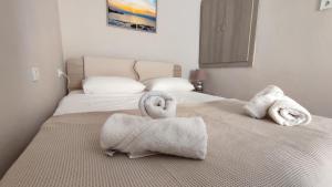 two towels on a bed in a bedroom at Aegean View in Ermoupoli