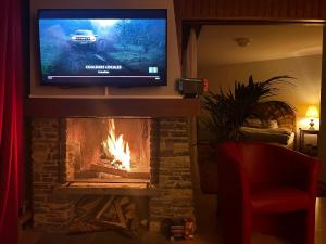 a fireplace with a television and a fire place at logement entier: appartement. Chez Gilbert Crans-Montana in Crans-Montana