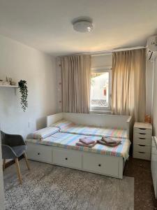 1 dormitorio con cama, ventana y silla en Chalet PuigVal 50m de la playa en Valencia