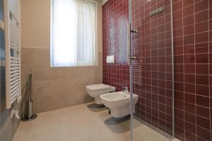 W łazience znajduje się toaleta oraz prysznic z czerwonymi kafelkami. w obiekcie Palazzo Borgo Trento - Royal Welcome w Weronie