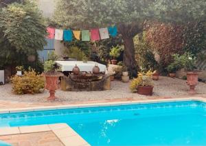 a swimming pool in a yard with a table and a tree at À la de Chambre de Lau in Noé