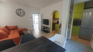 ein Wohnzimmer mit einem orangenen Sofa und einer Küche in der Unterkunft Apartment Pupi in Rijeka