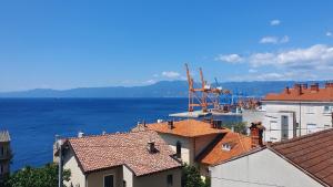 Blick auf das Wasser und die Dächer von Gebäuden in der Unterkunft Apartment Pupi in Rijeka