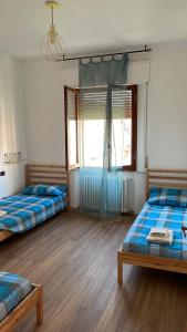 um quarto com duas camas e uma janela em Tulip’house em Sant'Albino