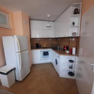a kitchen with a white refrigerator and a washer at "House of swallows" vacation home, close to Sofia in Makotsevo
