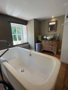 a large white bath tub in a bathroom at Le repaire des amoureux in La Roche-en-Ardenne