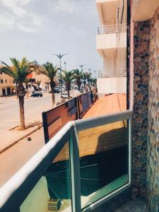 a balcony of a building with a street and palm trees at SULTANA Beach Riad in Saidia 