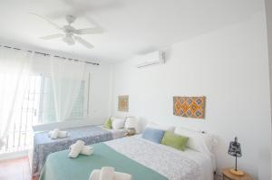 ein Schlafzimmer mit zwei Betten und einem Deckenventilator in der Unterkunft Villa El Dorado in Estepona + 50 Fotos