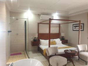 - une chambre avec un lit, une douche et une baignoire dans l'établissement SteyMorr Guesthouse, à Maun