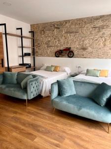 Un dormitorio con 2 camas y un sofá y una motocicleta en la pared en Hostal Zahara en Ferrol
