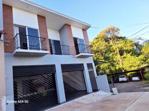 uma casa com duas portas de garagem e duas varandas em Hostel Vistas del Sol-Casa Victoria em San Isidro
