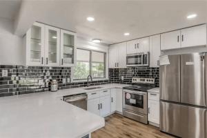 a kitchen with white cabinets and stainless steel appliances at Luxury and Cute Home in Irving 4 bedrooms,5 beds in Irving