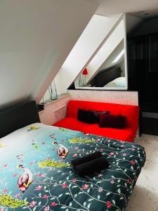 um quarto com uma cama e um sofá vermelho em Chez Hélène Luxury BNB em Maastricht