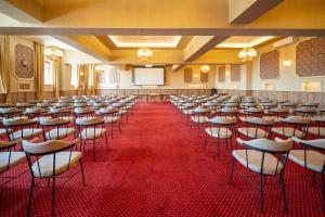 uma sala de conferências com filas de cadeiras e um quadro branco em Sevastokrator Relax & Congress em Arbanasi