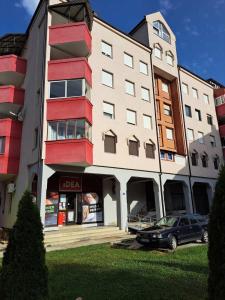 budynek z samochodem zaparkowanym przed nim w obiekcie Family apartment Tara w mieście Mojkovac