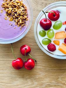 two plates of food with cherries and fruit on a table at Hotel Quellenhof in Naturno