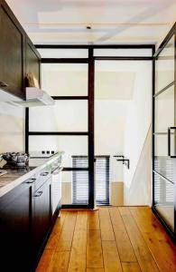 a kitchen with wooden floors and a large window at Chez Hélène Luxury BNB in Maastricht