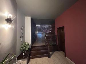 a hallway with stairs and a red wall at Hotel Stadion in Oradea