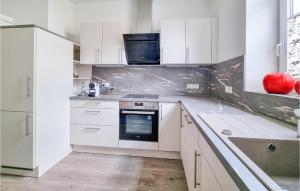 una cocina blanca con armarios blancos y fregadero en Lovely Apartment In Schwarzatal With Wifi, 