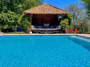 a gazebo with chairs and a swimming pool at Domaine De Sainte Annette in Callian