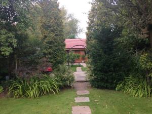 a garden with a pathway leading to a house at Manor Garden Lodge in Wirral