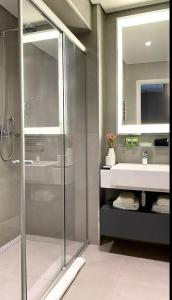 uma casa de banho com uma cabina de duche em vidro e um lavatório. em Studio Alpha Stay One em Barueri