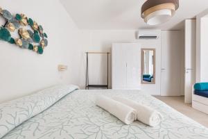 1 dormitorio blanco con 1 cama con 2 toallas en Villa Briosa Maldive del Salento Pescoluse, en Torre Pali
