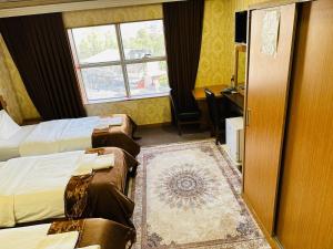 a hotel room with two beds and a window at Altin Saray Hotel Erbil in Erbil
