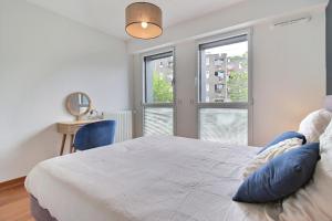 um quarto com uma cama grande e 2 janelas em L'Universel em Vannes
