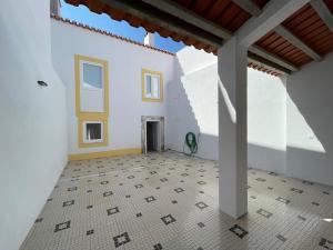 Habitación con suelo de baldosa y paredes blancas. en Charming Benavente, en Benavente