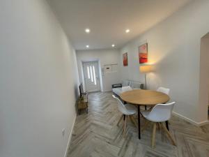 a dining room with a wooden table and white chairs at Charming Benavente in Benavente