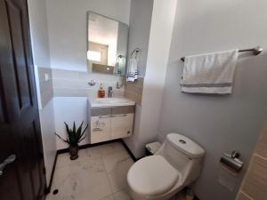 een witte badkamer met een toilet en een wastafel bij Victoria House-Sun View Hostel in San Isidro
