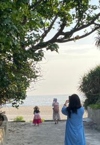 een vrouw die een foto neemt van twee meisjes op het strand bij Hiên Cát homestay in Hue