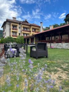 un patio con sillas y flores frente a un edificio en Kris Guest House, en Devin