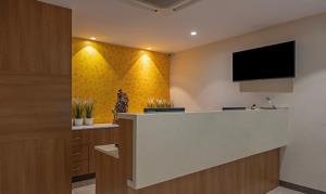 a lobby with a reception desk with a flat screen tv at Treebo Trend Seasons Comfort in Visakhapatnam