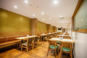 a row of tables and chairs in a restaurant at Treebo Trend Seasons Comfort in Visakhapatnam