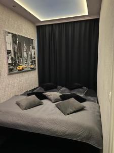 - un grand lit dans une chambre dotée de rideaux noirs dans l'établissement Lans Apartments SPA Menden Sauerland, à Menden