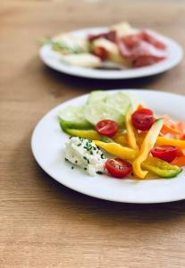 dos platos de comida con verduras en una mesa en Hotel Quellenhof en Naturno