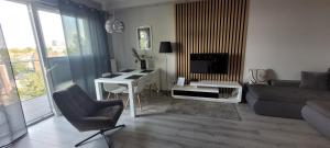 a living room with a couch and a table and a television at Apartament Neptun in Olsztyn