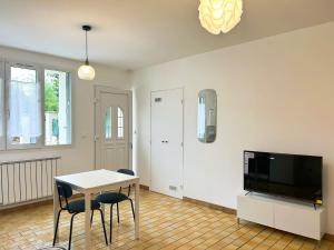 Una sala de estar con una mesa y un televisor. en La Maison de Mickey - Disneyland Paris, en Bailly-Romainvilliers