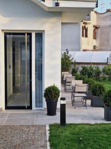 une porte d'entrée d'un bâtiment avec des chaises et des plantes dans l'établissement Elios Badino B&B, à Terracine