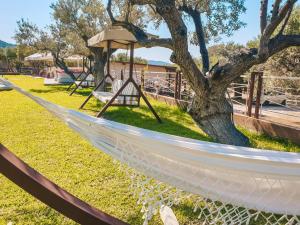 a hammock in a park with a tree at Aroma Studios and Apartments in Vourvourou
