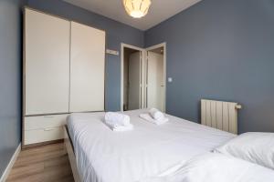 2 camas en un dormitorio con paredes azules y blanco en CasaVasca - Appartement Cosy et Calme, WiFi - Parking, en Hendaya