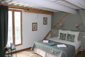 a bedroom with a bed and a large window at Le Mas des Cerisiers JACUZZI et SAUNA inclus pour tous les logements in Avignon